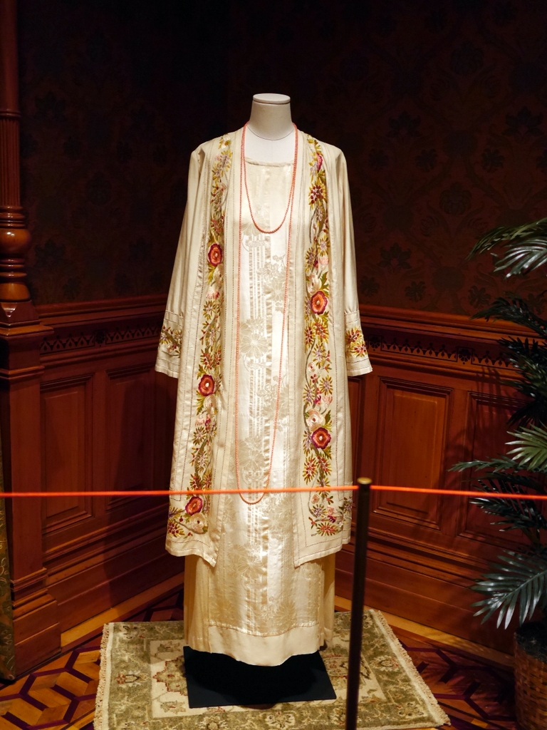 ダウントン アビー DowntonAbbey 衣装展 ファッション シカゴ ドライハウス ミュージアム DRESSING DOWNTON 時代考証   コーラ・クローリーのフローラル刺繍ボーダー付きのコートとフローラルセルフパターンのドレス（シーズン3、1920年） 